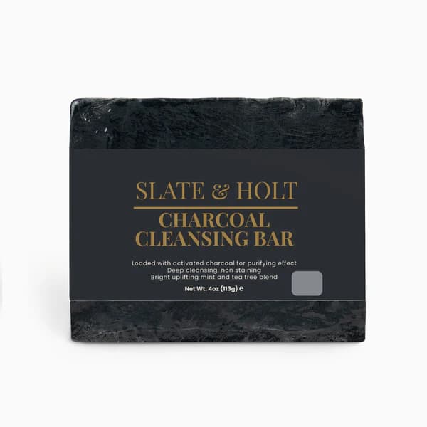 Black charcoal cleansing bar with 'Slate & Holt' branding on a white background