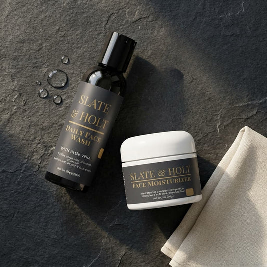 Slate & Holt daily face wash and face moisturizer on a dark stone surface with a beige towel.